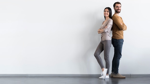 Free photo positive adult male and woman posing with copy space