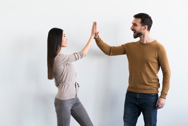 Positive adult male and young woman high fiving