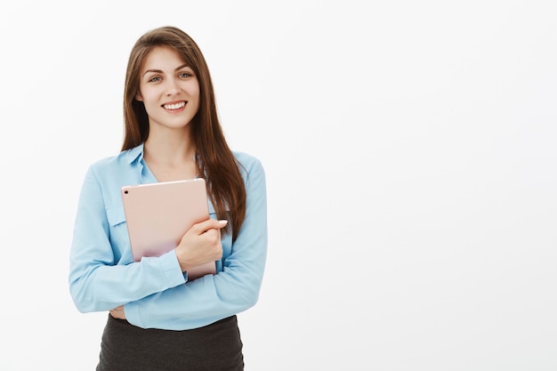 Positive attractive brunette businesswoman posing in the studio