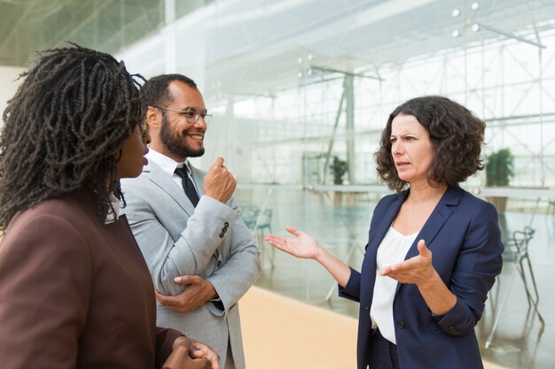 Positive business colleagues chatting outside