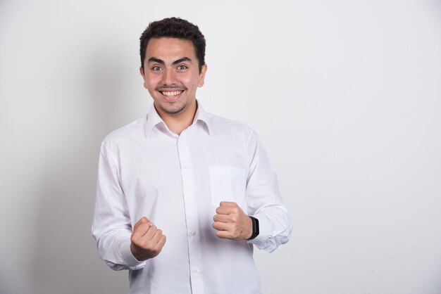 Positive businessman standing on white background.