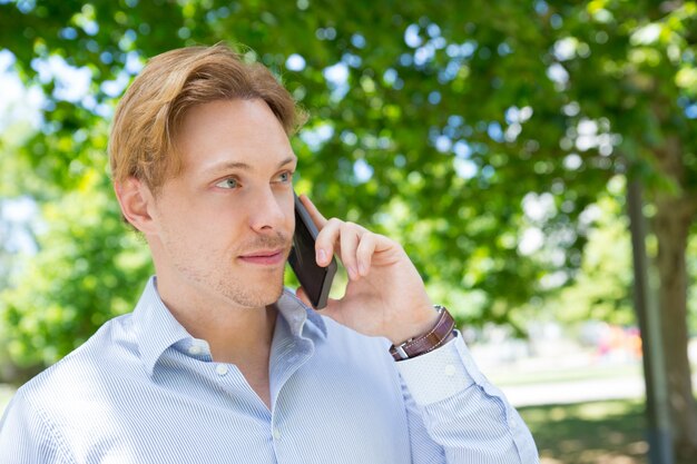 Positive calm entrepreneur calling on mobile phone