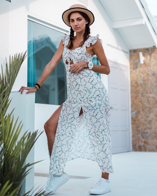 Free photo positive calm woman in light summer dress, straw hat, tropical location