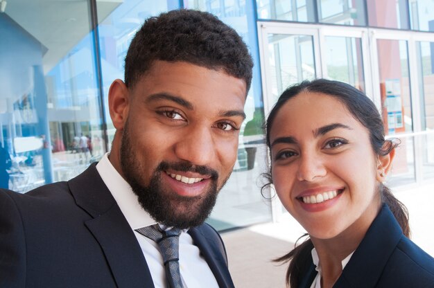 Positive colleagues posing and taking selfie photo outdoors