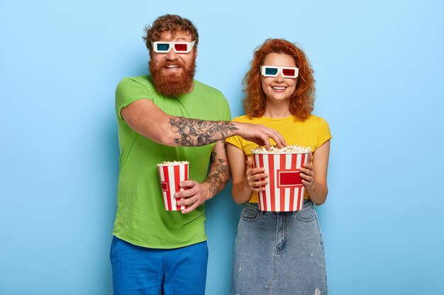 Positive couple come on late night film in cinema, eat delicious popcorn