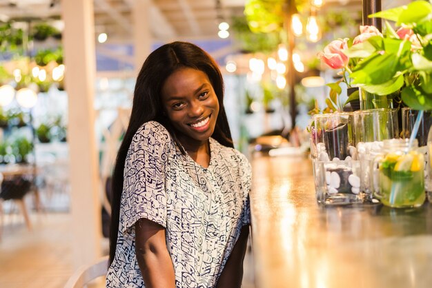 Positive dark skinned mixed race female ejoys good rest at coffee shop