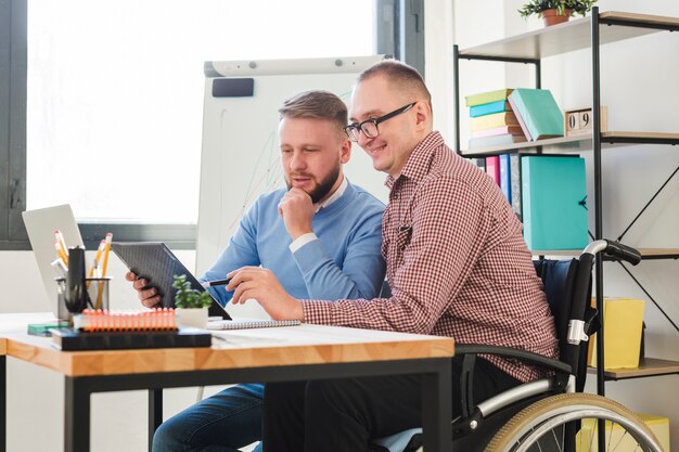 Positive disabled worker together with manager at the office