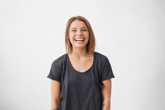 Positive emotions and human expressions concept. Pretty young woman with broad smile showing her excitement