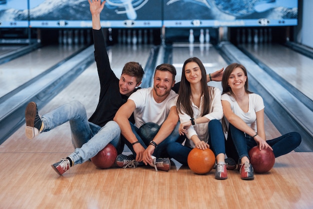 Emozioni positive. i giovani amici allegri si divertono al bowling durante i fine settimana