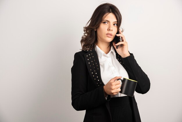 Positive employee talking on telephone on white