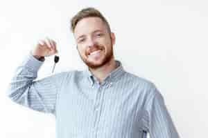 Free photo positive face of young realtor holding car key