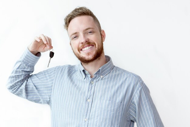 Positive face of young realtor holding car key