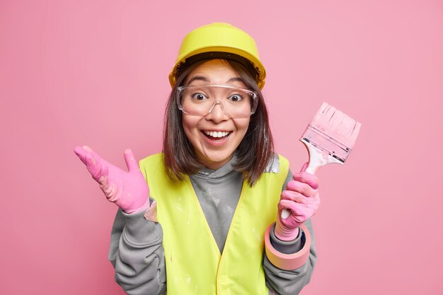 Free photo positive female maintenance worker with painting brush