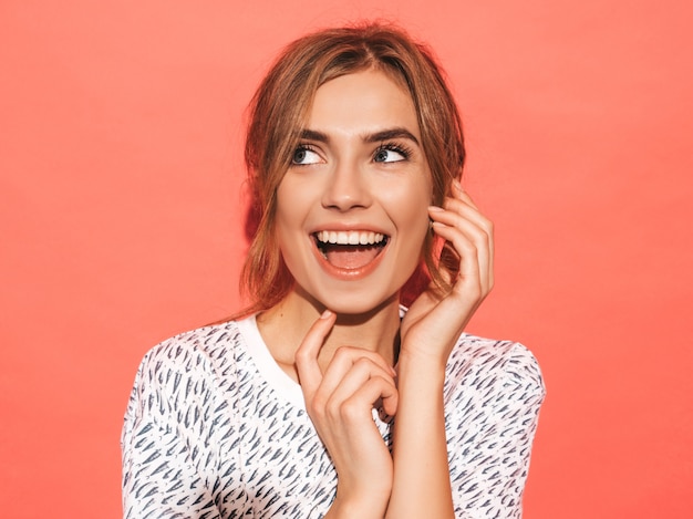 Positive female smiling. Funny model posing near pink wall in studio