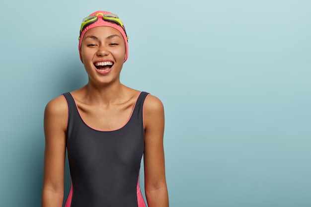 Free photo positive female swimmer posing with goggles