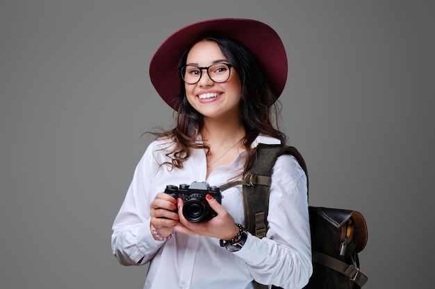 Бесплатное фото Позитивная туристка с фотокамерой и рюкзаком для путешествий.