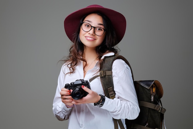 写真のカメラと旅行のバックパックでポジティブな女性の観光客。