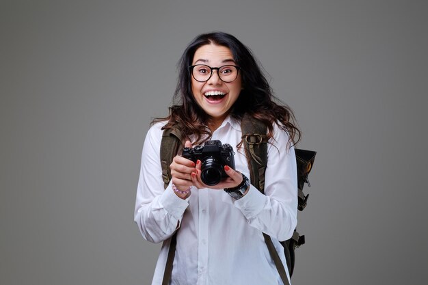 写真のカメラと旅行のバックパックでポジティブな女性の観光客。