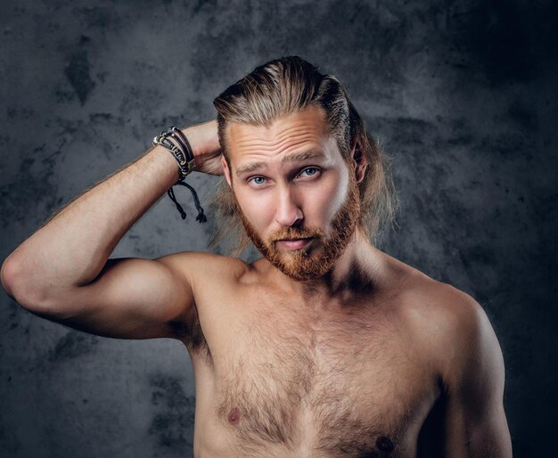 Positive, gentle redhead bearded male posing in a studio on grey background.