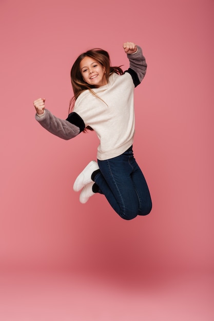 Positive girl jumping and smiling isolated