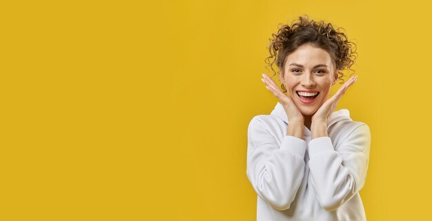 Free photo positive girl with curly hair standing smiling