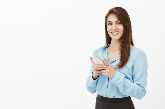 Positive good-looking brunette businesswoman posing in the studio