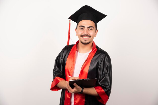 Positive graduate student with diploma looking at camera on white.