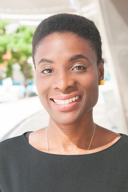 Positive happy black lady posing outdoors and smiling