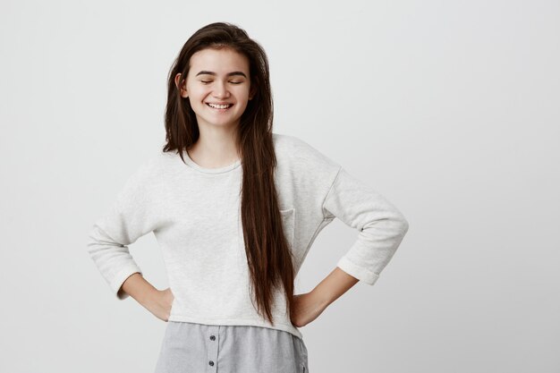 Positive happy brunette female closing eyes