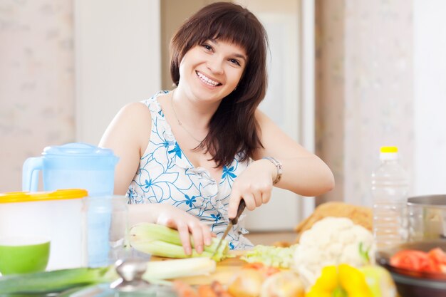 positive housewife cooking with celery