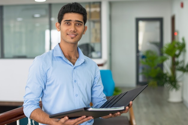 Positive Indian financial advisor holding open folder