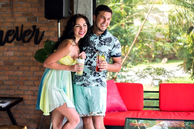 Positive indoor portrait of happy couple spending time at stylish tropical restaurant, trendy outfits, relation couple goals.