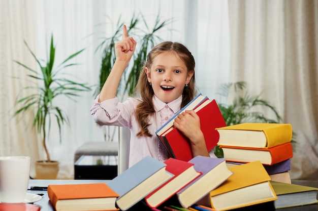 Positive little girl likes reading a lot of books.