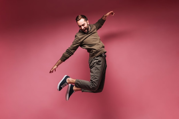 Positive man laughing and jumping high on isolated background