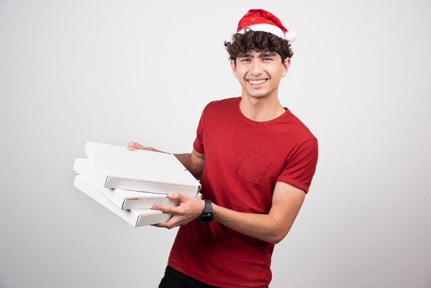 Positive man posing with pizza boxes.