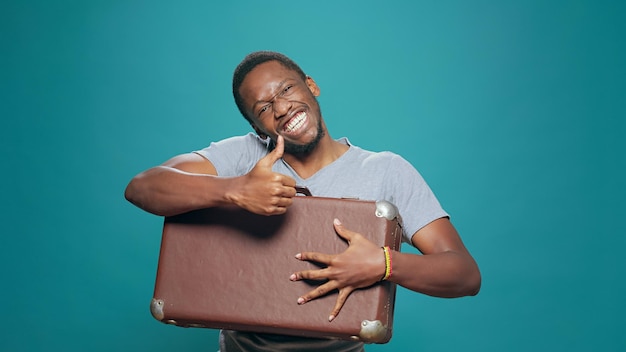 Positive person preparing suitcase baggage to leave on journey, travelling abroad to go on holiday vacation trip. Excited happy man holding voyage luggage to do cityscape adventure.