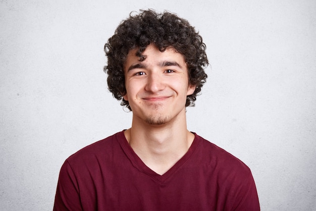 Positive pleased male with curly hair