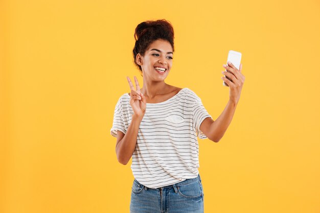 Positive pretty lady making selfie on phone isolated