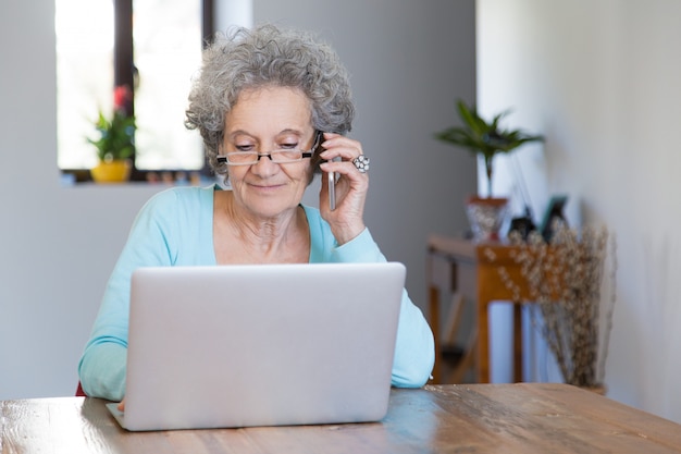 Positive retired lady working at home