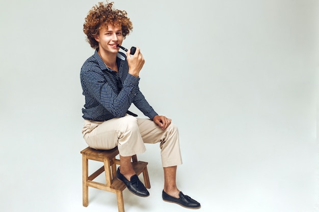 Positive retro man dressed in shirt sitting and posing