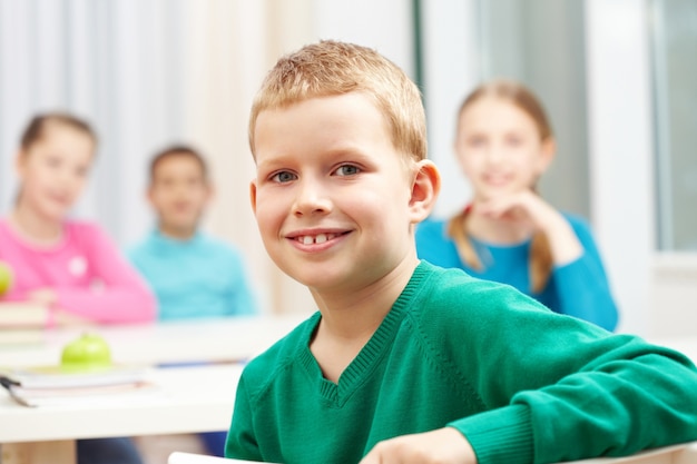 Free photo positive schoolboy with classmates background