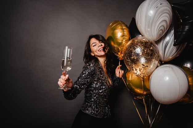 Positive smiling woman dancing on wall