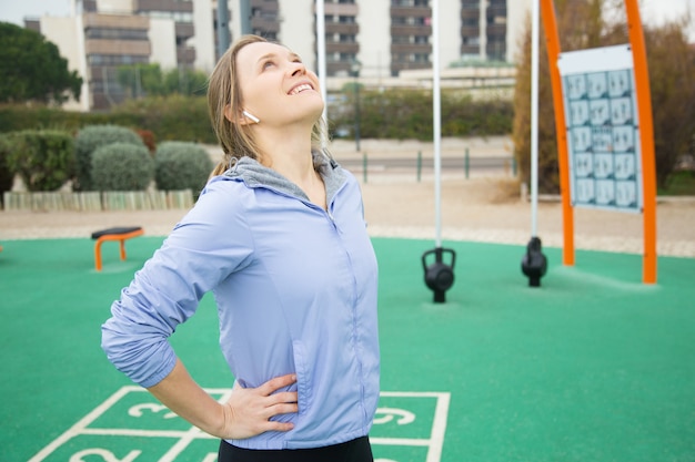 Positive sporty girl warming up neck