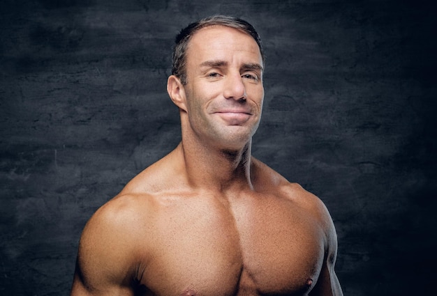 Бесплатное фото Позитивный спортивный, мускулистый мужчина средних лет с бритой грудью.