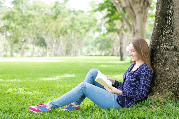 Positive student girl adoring reading book