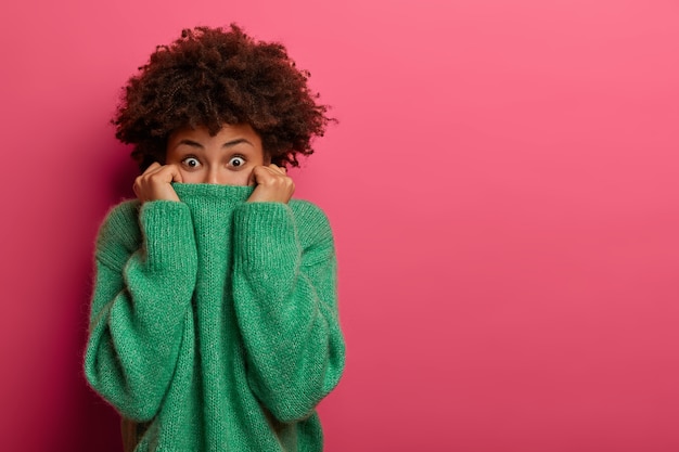 Foto gratuita la donna afroamericana sorpresa positiva nasconde il fronte con il maglione, gioca e sembra eccitata