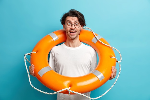 Free photo positive surprised man poses with inflated lifebuoy