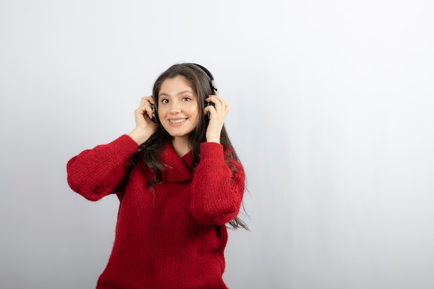 Positive teenager listens music in stereo headphones . 