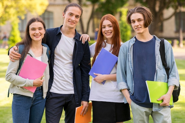 Позитивные подростки позируют вместе в университете