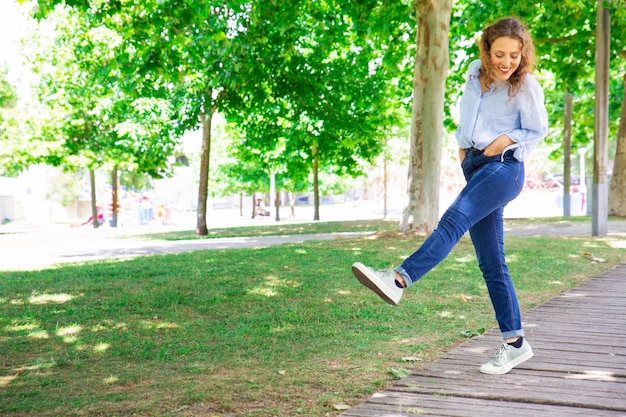 Positive woman ambling in park